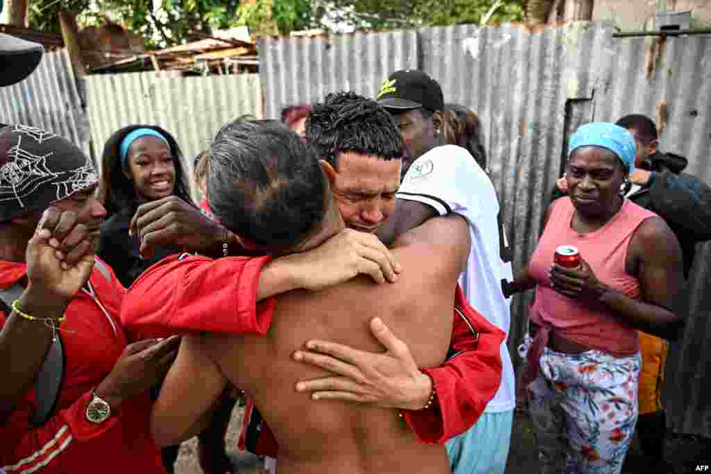 Marlon Brando Díaz (C), encarcelado por su participación en las protestas antigubernamentales de julio de 2021, saluda a sus familiares después de ser liberado de la prisión en el barrio de Guinera en La Habana el 16 de enero de 2025.&nbsp;&nbsp;YAMIL LAGE / AFP