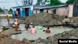 Niños se bañan en una zanja creada por el salidero de una tubería averiada en una calle de La Habana. (Facebook/Blanca Díaz Hernandez/Archivo)